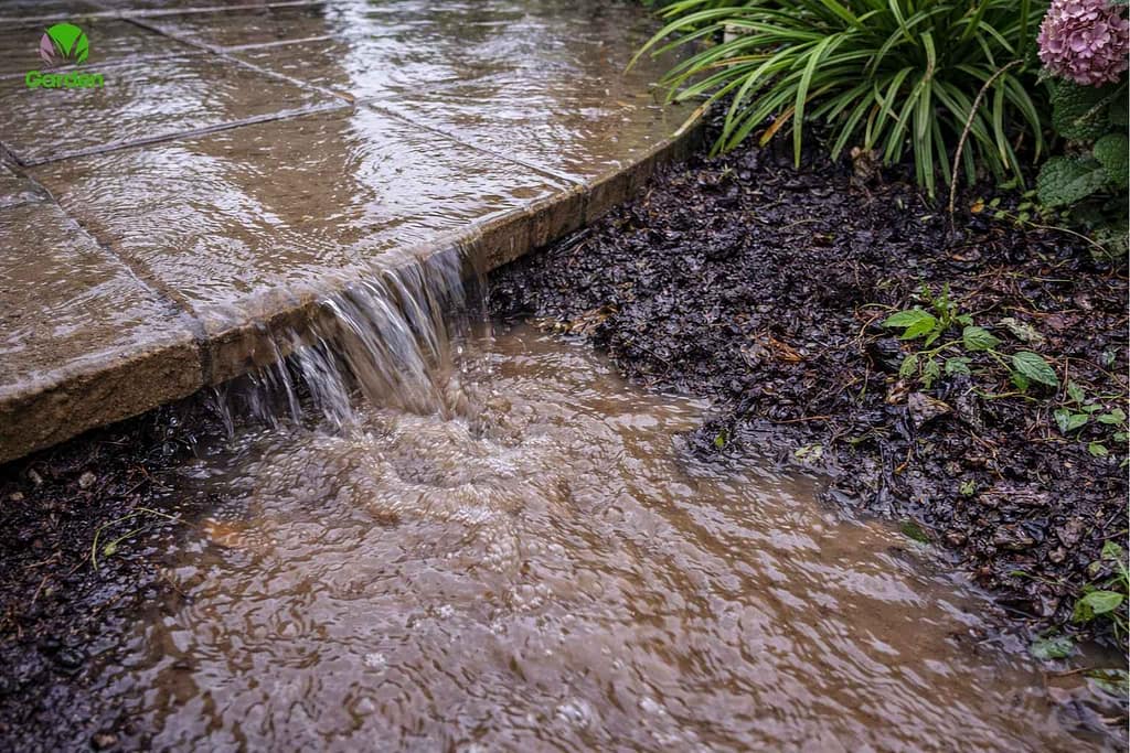 Rainwater runoff flowing from patio into garden soil causing waterlogging